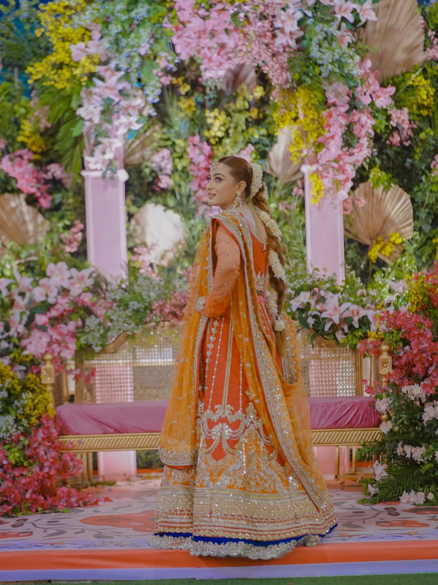 Bride in a red dupatta with henna hands and traditional gold jewellery