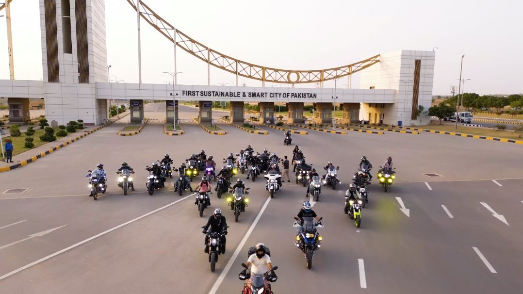 Wedding motorcade of riders passing through a city gateway
