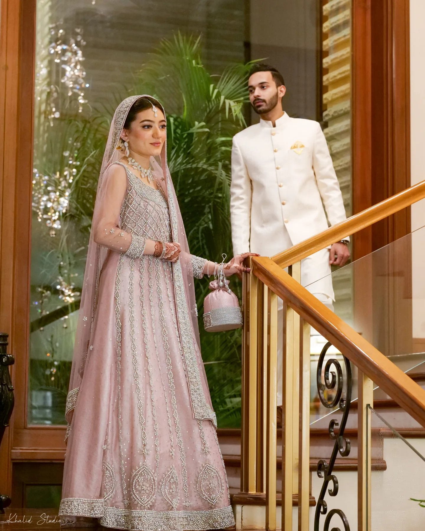 Bride and groom standing together on a staircase landing